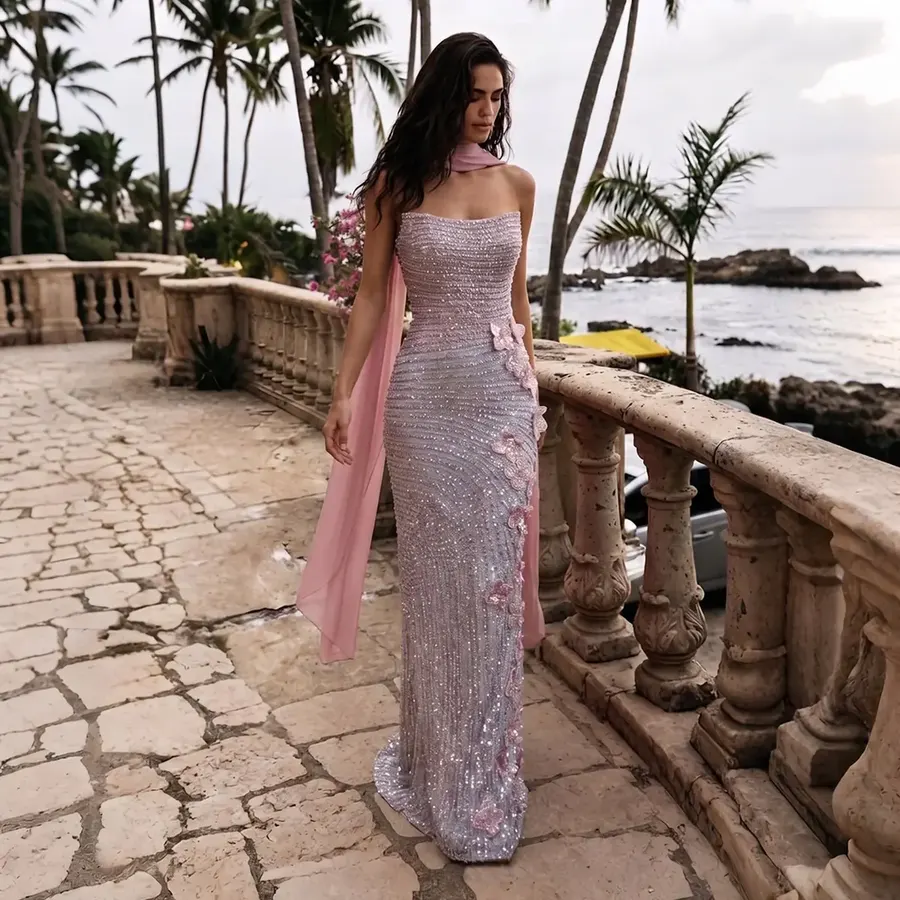 Woman wearing a sequined evening gown by the coast