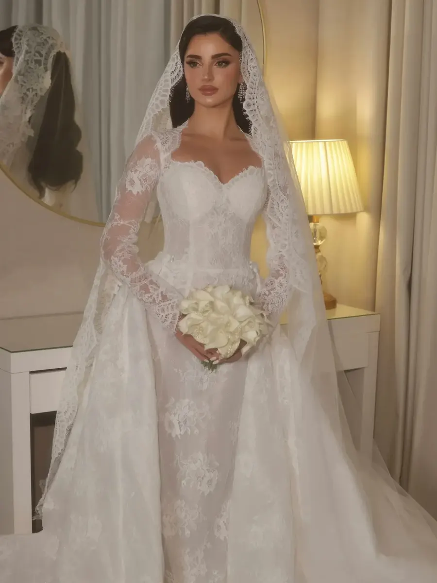 Bride wearing a lace wedding gown and veil indoors