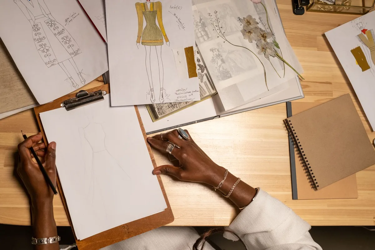 Fashion sketches and creative references on a designer worktable
