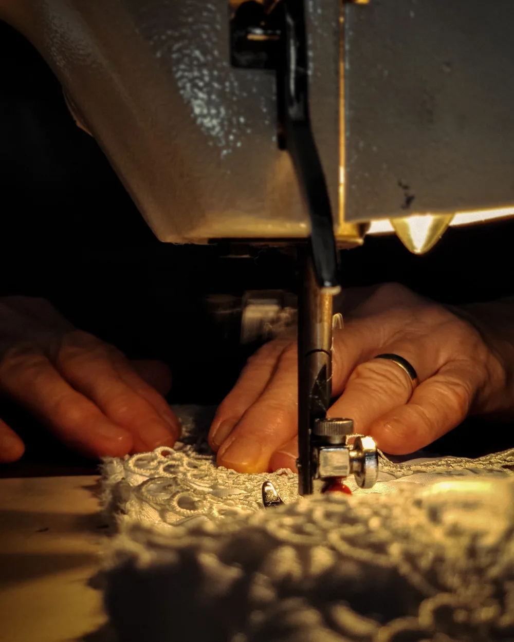 Lace being carefully stitched at a sewing machine